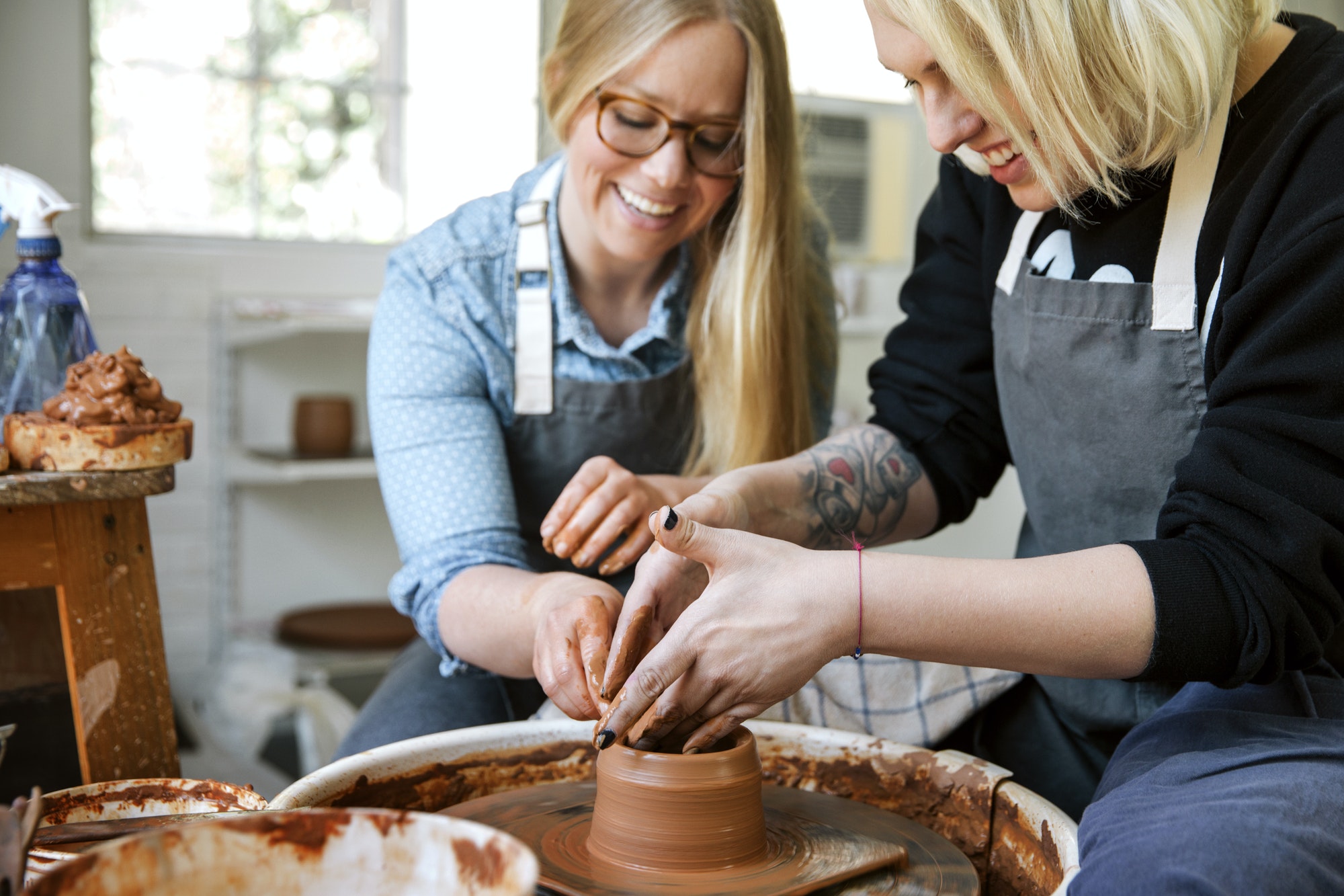 happy-women-working-on-pottery-wheel-in-workshop.jpg